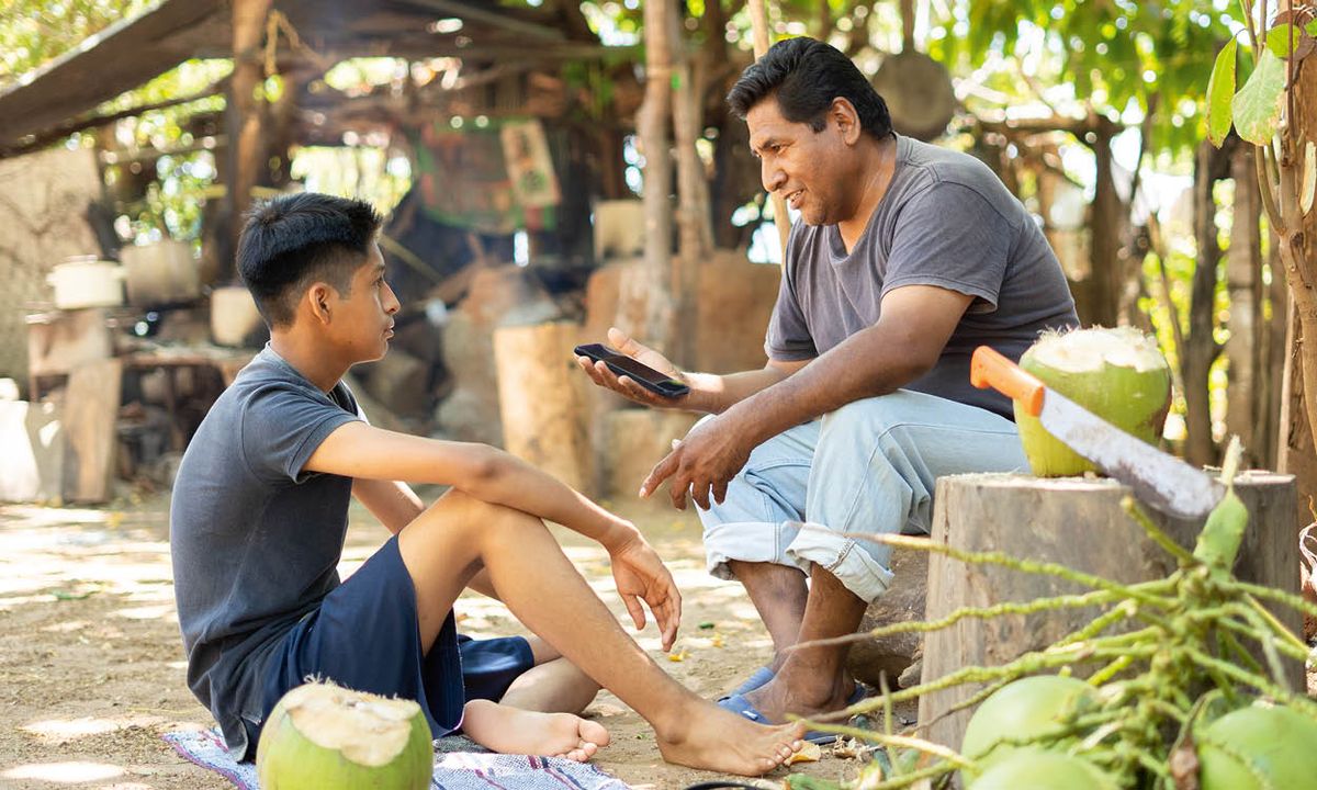 තාත්තා කෙනෙක් ෆෝන් එකක් අතේ තියාගෙන පුතා එක්ක එළියේ කතා කරකර ඉන්නවා.