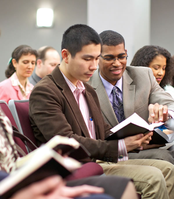 Människor läser Bibeln på ett möte.