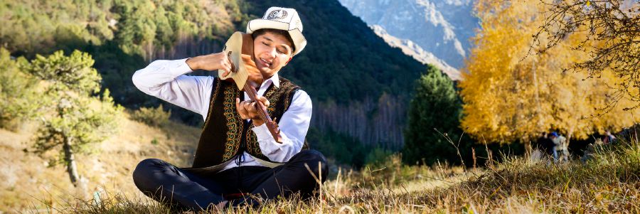 En ung man spelar instrumentet komuz