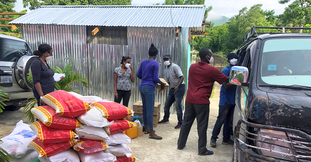 Bröder och systrar på Haiti packar en bil med mat.