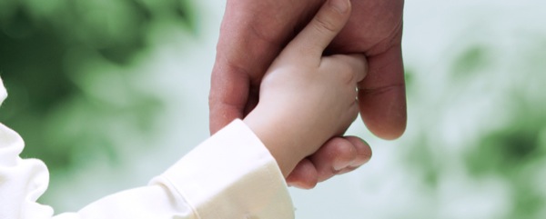 En pappa håller sin sons hand