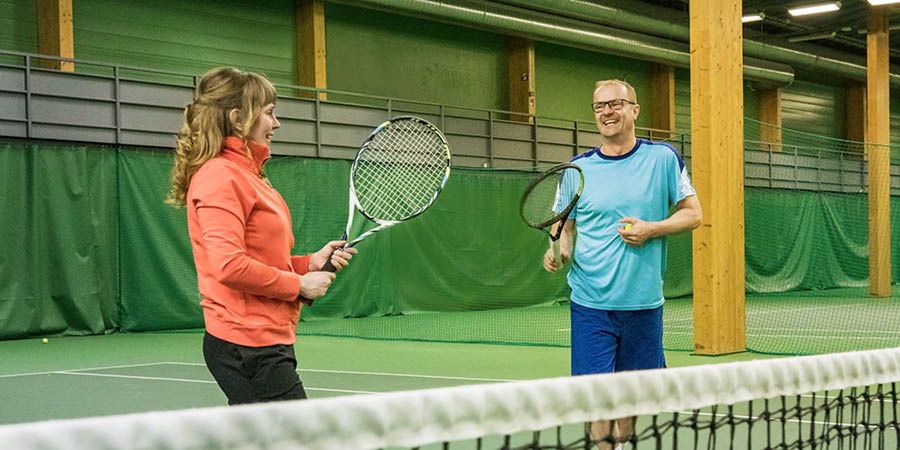 Veli Paloheimo ger en kvinna tennislektioner.
