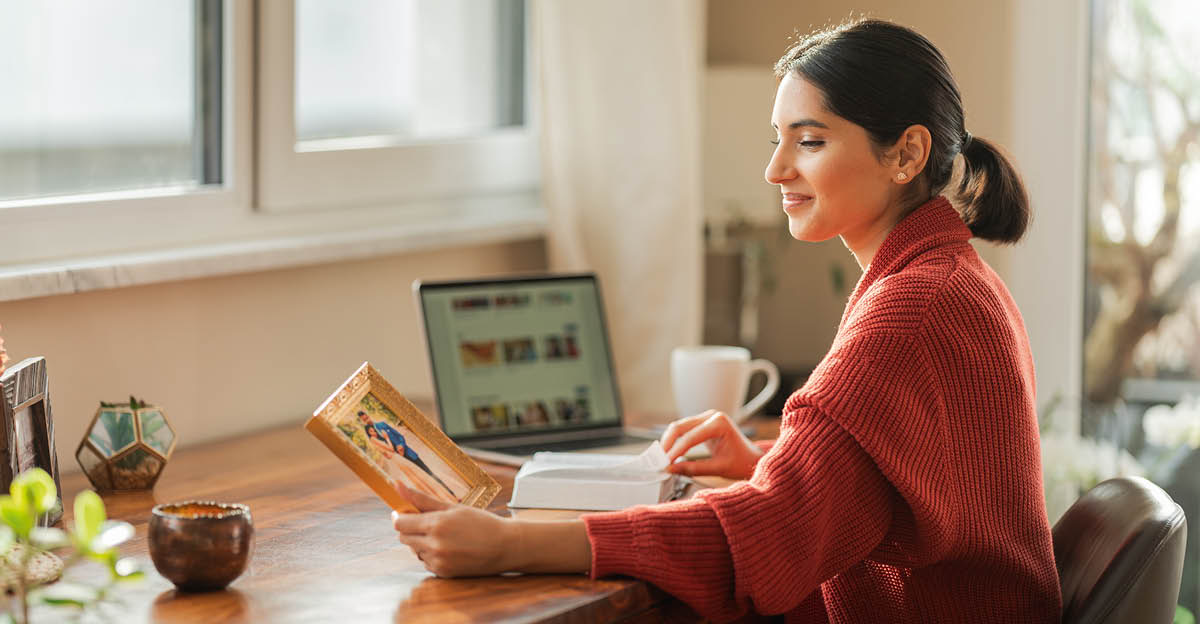 Samma kvinna tittar med värme på ett foto från sin bröllopsdag. Framför henne ligger en uppslagen bibel.