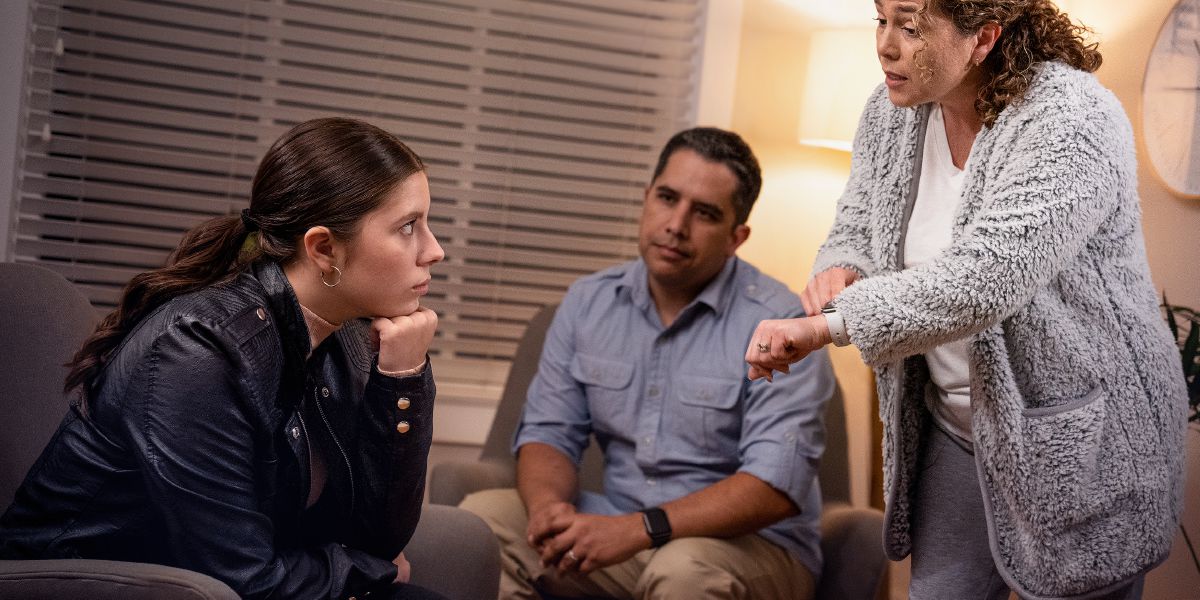 Oroliga föräldrar pratar med sin dotter som har kommit hem senare än de hade kommit överens om.