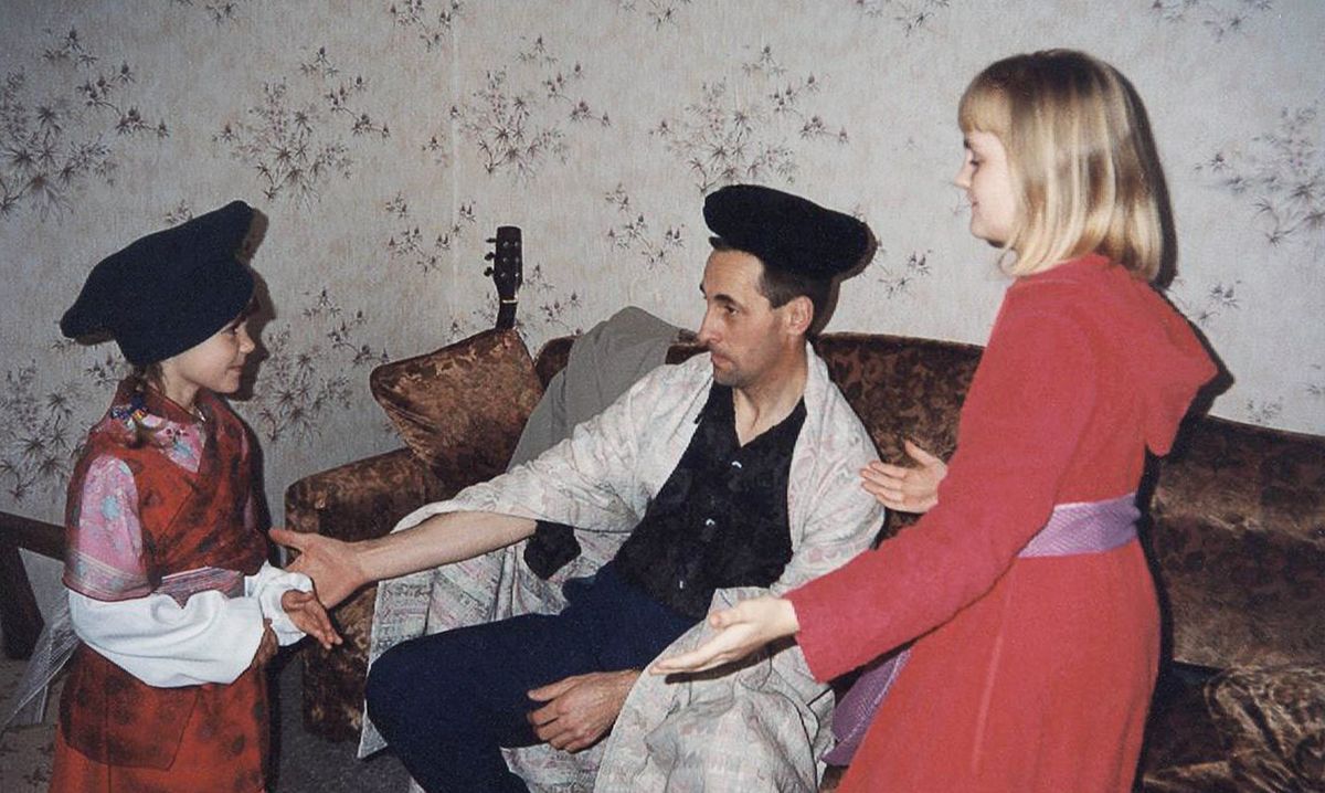 Virgilijus har en hatt på sig som ska föreställa en krona och en filt som mantel när han och hans två döttrar spelar upp en scen från Esters bibelbok.