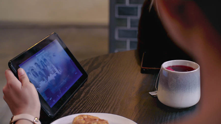 En scen ur videon ”Upplev glädjen med att göra lärjungar – Bli skickligare – Illustrera huvudtankar”. Neeta visar en video för Jess.