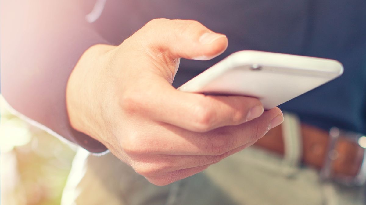 En broder tittar på sin smartphone.