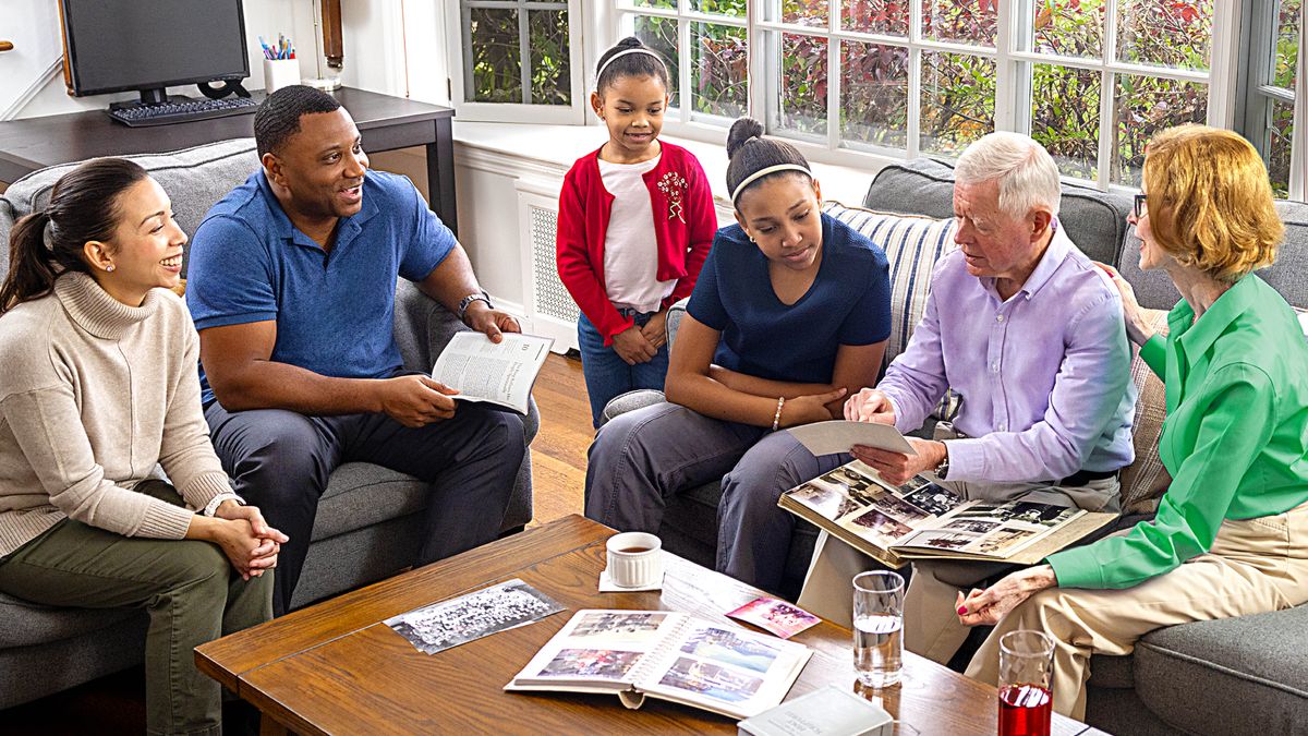 Familjen som fanns med på bild i förra veckans programpunkt ”Tips för den andliga familjekvällen”. De har bjudit hem ett äldre par till sin familjekväll och sitter och lyssnar när paret berättar erfarenheter och visar bilder.