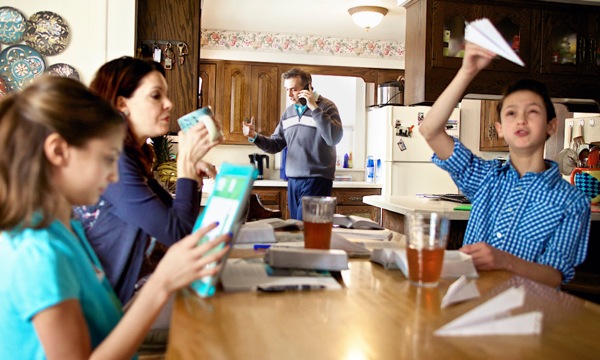 Ett kaotiskt familjestudium – alla i familjen håller på med sitt.