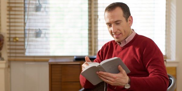 En man läser Bibeln.