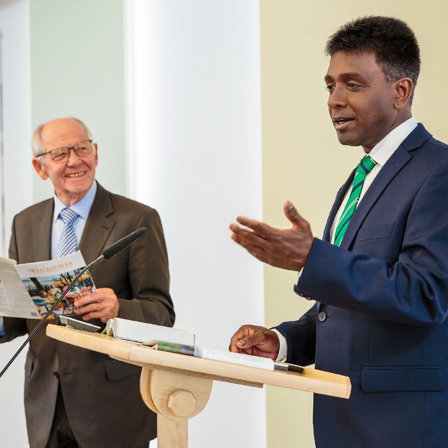 En äldre broder ser stolt och glad ut när en yngre broder som han har övat leder vakttornsstudiet.