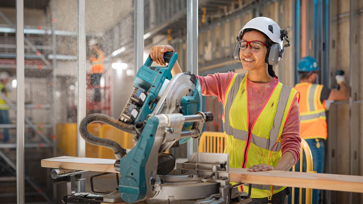 Samma syster använder en kapsåg på ett byggprojekt.