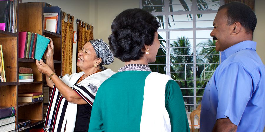 En intresserad kvinna i Indien visar sin litteratursamling från 70- och 80-talet för två pionjärer