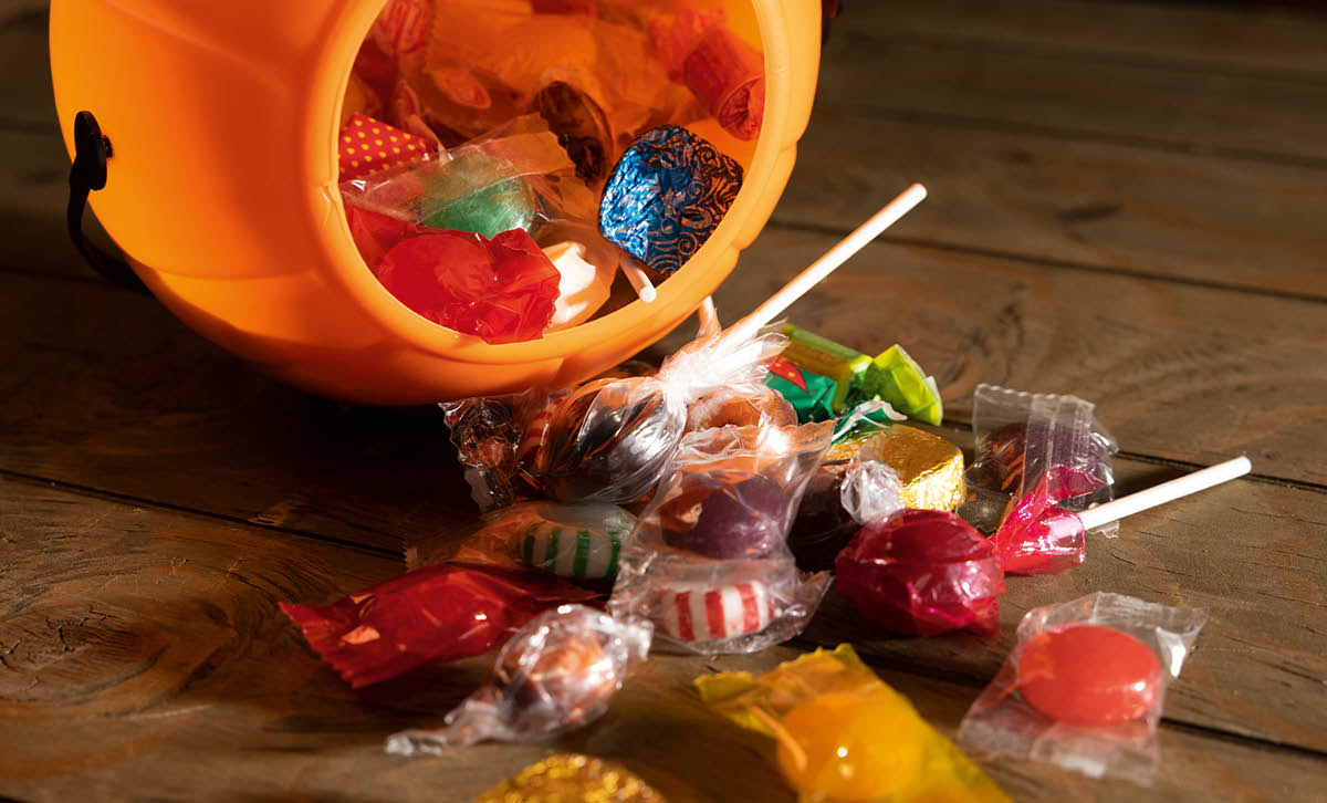 Peremende mbalimbali zimemwagika mezani kutoka kwenye boga la plastiki lenye rangi ya chungwa.