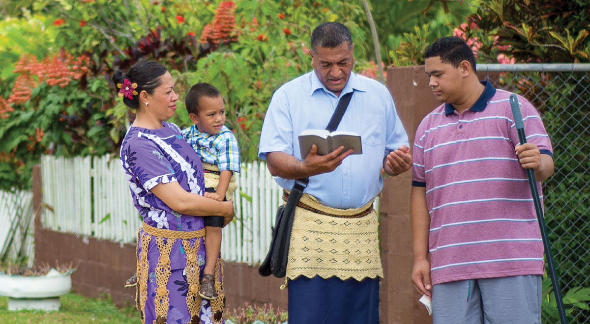 Solomone Tonga na familia yake wakimfundisha mwanamume Biblia