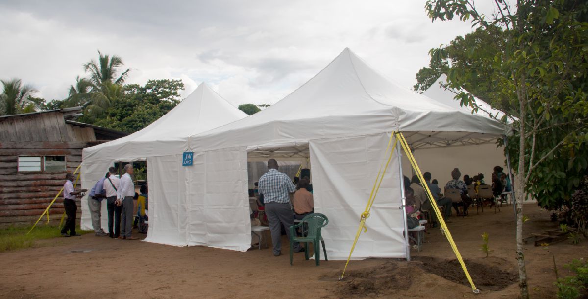 Kikundi cha watu kilichohudhuria mkutano uliofanywa katika hema kubwa lililojengwa msituni.