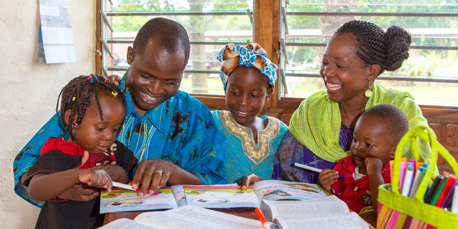 Wenzi wa ndoa ambao ni Mashahidi wa Yehova wakijifunza Biblia pamoja na watoto wao