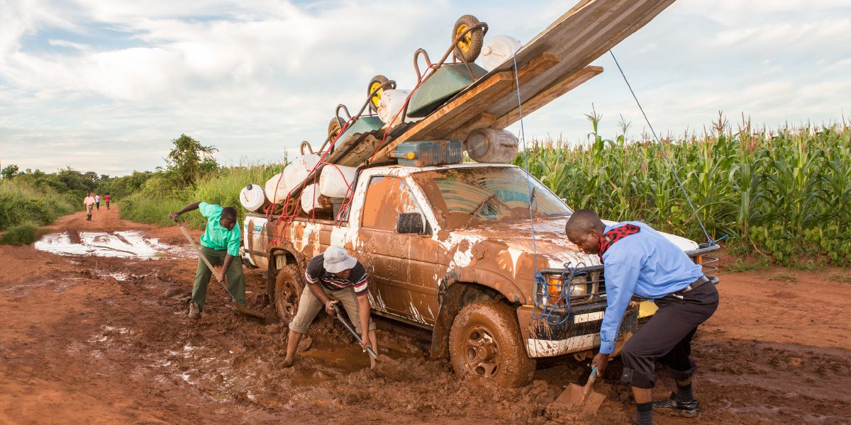 Wanaume wakichimba ili kulitoa gari lililokwama kwenye matope