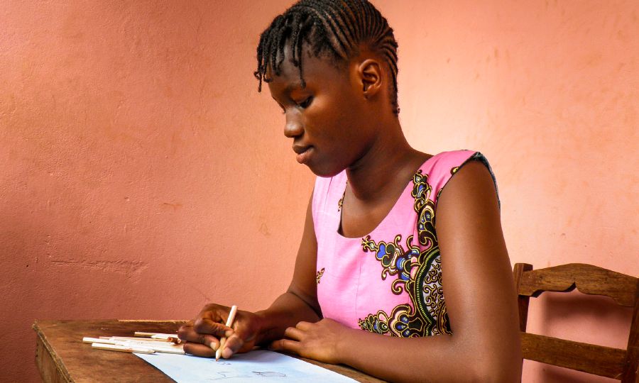 Aminata, mwanafunzi mwenye umri wa miaka 15 nchini Guinea-Bissau, akichora picha ya Paradiso