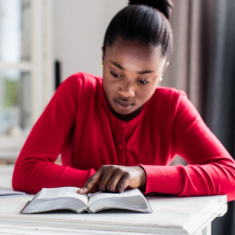 Kijana mwanamuke anasoma Biblia