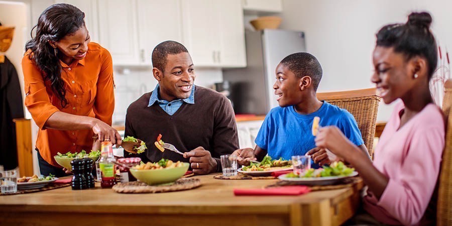 Familia moja inafurahia mazungumuzo wakati wa chakula