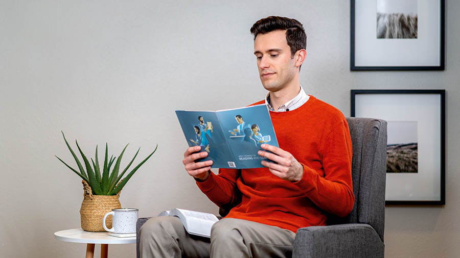 A brother considering a lesson in the brochure “Apply Yourself to Reading and Teaching.”