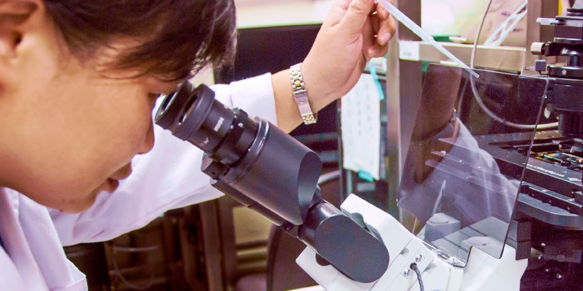 ผู้​หญิง​กำลัง​ส่อง​กล้อง​จุลทรรศน์