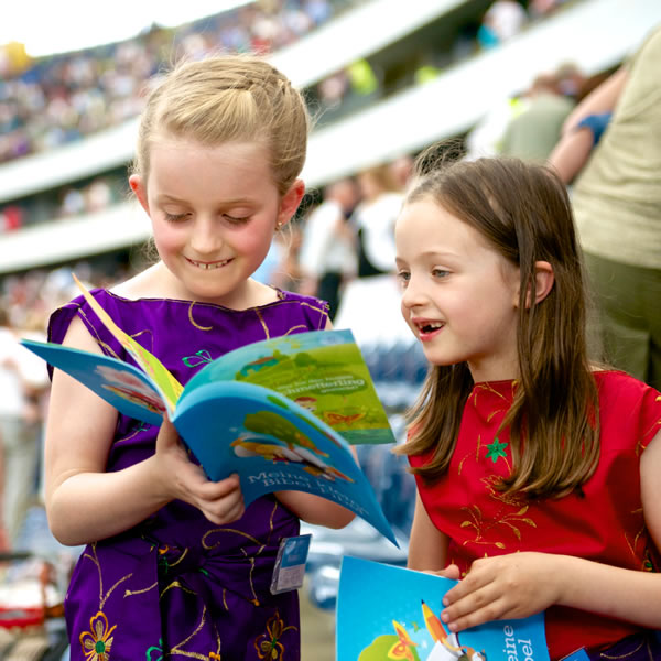 เด็ก 2 คน​กำ​ลัง​ดู​จุลสาร​เรื่อง​ที่​หนู​เรียน