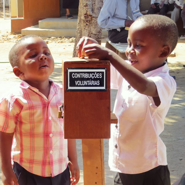 เด็ก 2 คน​ใส่​เงิน​ลง​ใน​กล่อง​บริจาค