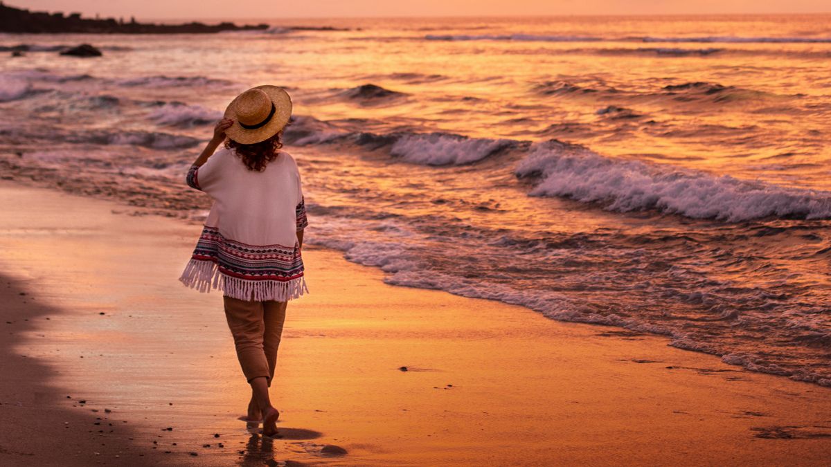 พี่​น้อง​หญิง​คน​หนึ่ง​เดิน​อยู่​บน​ชาย​หาด​ตอน​ที่​ดวง​อาทิตย์​ตก