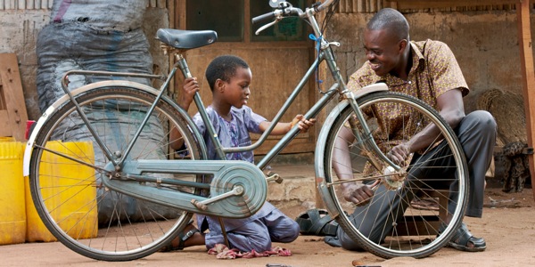 Un padre y su hijo reparan juntos la bicicleta