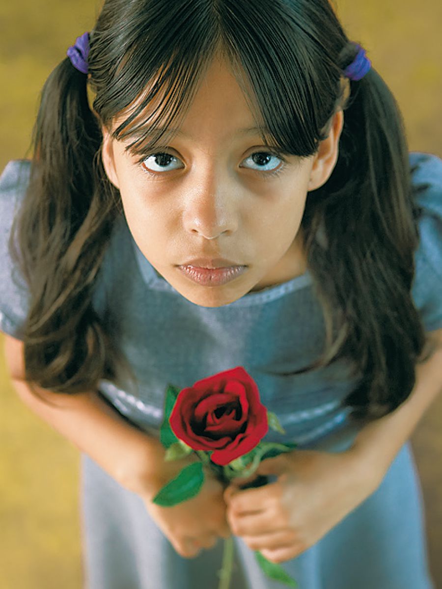 Una niña con una rosa en las manos