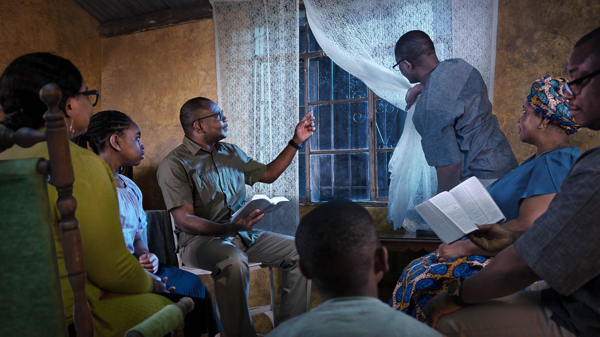 Durante la gran tribulación, varios hermanos leen la Biblia juntos en una habitación por la noche. Miran por la ventana, y uno de ellos señala al cielo.