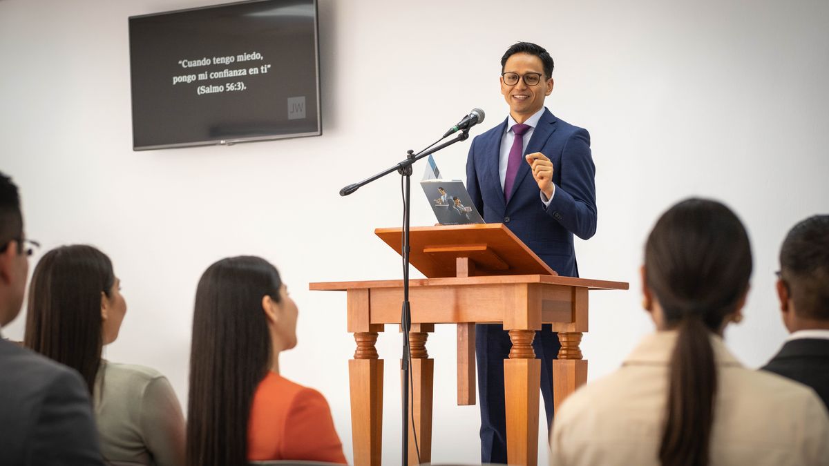 Durante una reunión de entre semana, el presidente usa el folleto “Seamos mejores lectores y maestros” para felicitar y aconsejar a una estudiante.