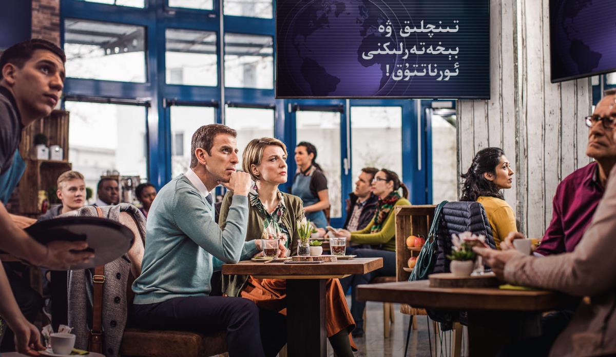 رېستورانغا كە‌لگە‌ن ئادە‌ملە‌ر تېلېۋىزوردىن «جىددىي خە‌ۋە‌رلە‌ردە» «تىنچلىق ۋە بىخە‌تە‌رلىك» ئېلان قىلىنغانلىقىنى ئاڭلاپ،‏ ھاڭ-‏تاڭ بولىۋاتىدۇ.‏ گۇ‌ۋاھچى ئە‌ر-‏ئايال بۇ خە‌ۋە‌رگە ئالدىنىپ قالمىغان
