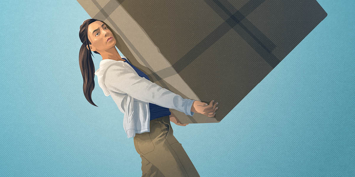 Дівчина-підліток намагається нести величезну коробку.