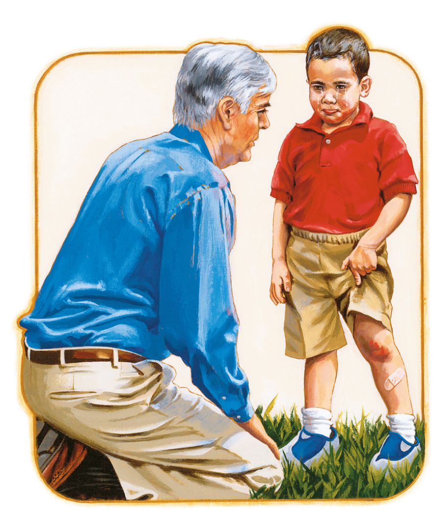 Чоловік потішає хлопчика, який розбив коліно