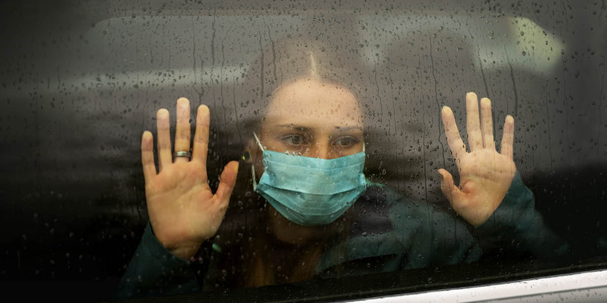 Дівчина-підліток дивиться у вікно.