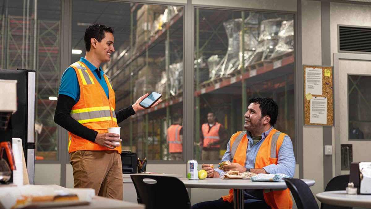 Під час обідньої перерви брат показує співробітнику біблійний вірш на своєму телефоні.