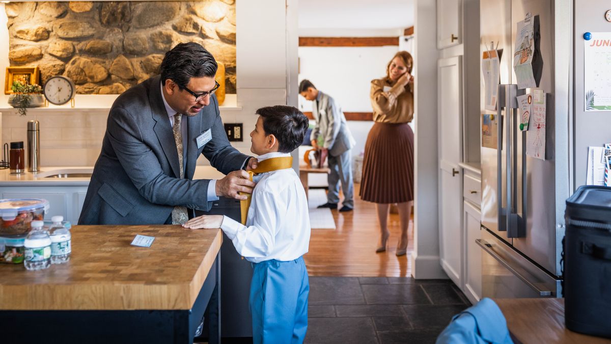 Сім’я збирається на конгрес. Батько зав’язує краватку молодшому синові. Мати і старший син уже майже готові.