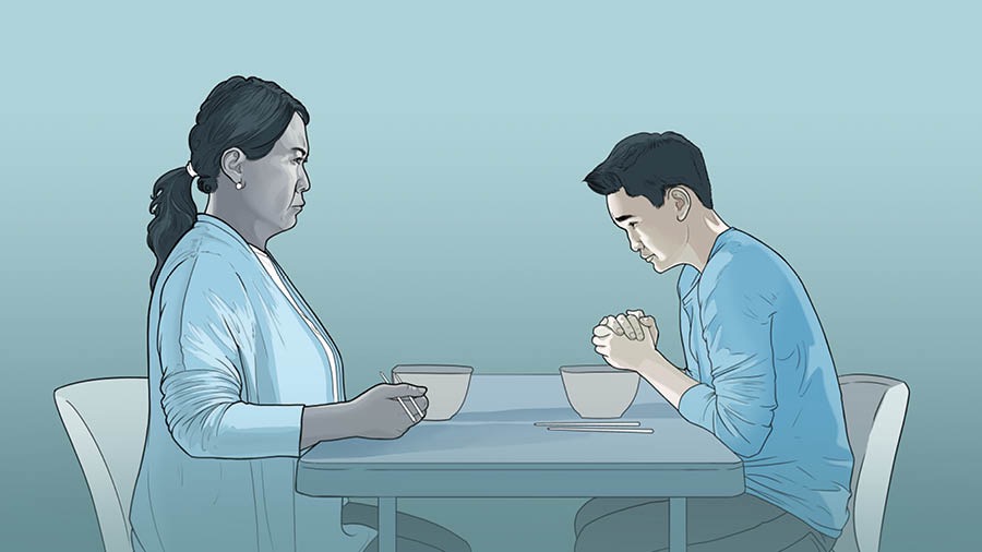 Một em nam rụt rè cầu nguyện trước mặt người mẹ không cùng đức tin