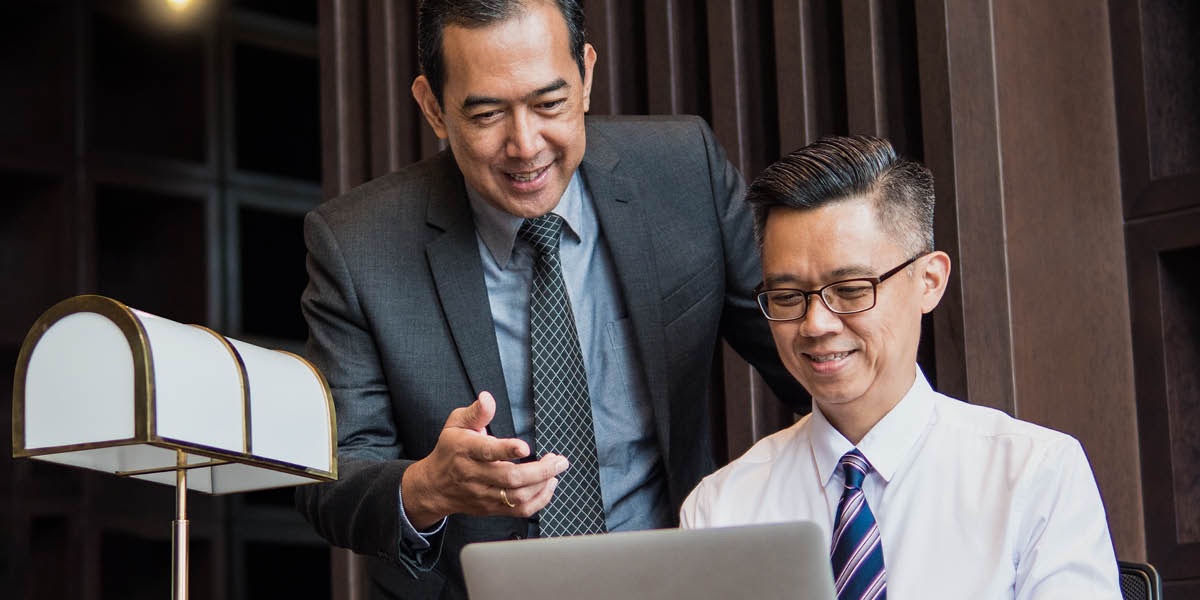 Một doanh nhân đọc cho người thư ký đánh lá thư trên máy.