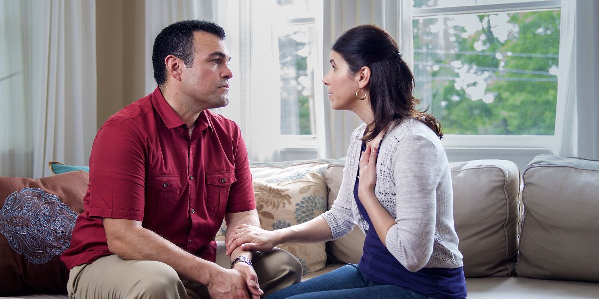 Un hombre escucha con atención a su esposa