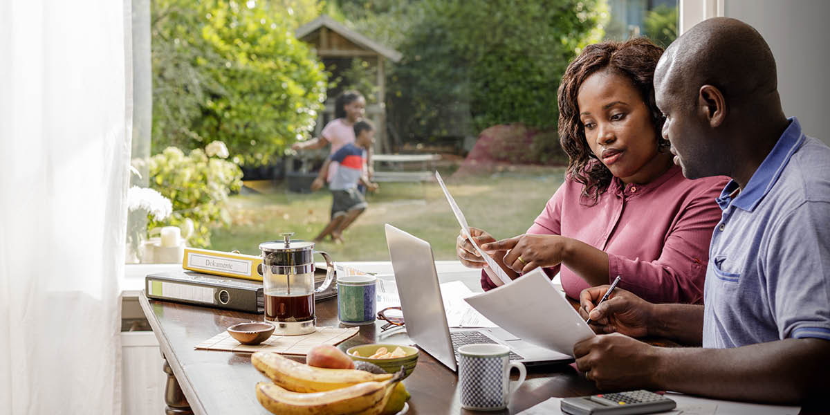 Papa and mama de talk about money matter and their children de play for backyard.