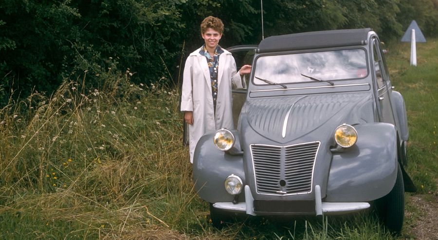 Danièle Bockaert stands near their small car
