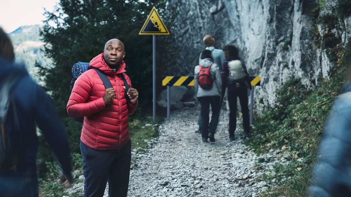 Umfana ume kwindlela enamatye nenebhodi ezichaza ubungozi. Abanaye abantu abahamba kule ndlela abazihoyanga ezi bhodi.