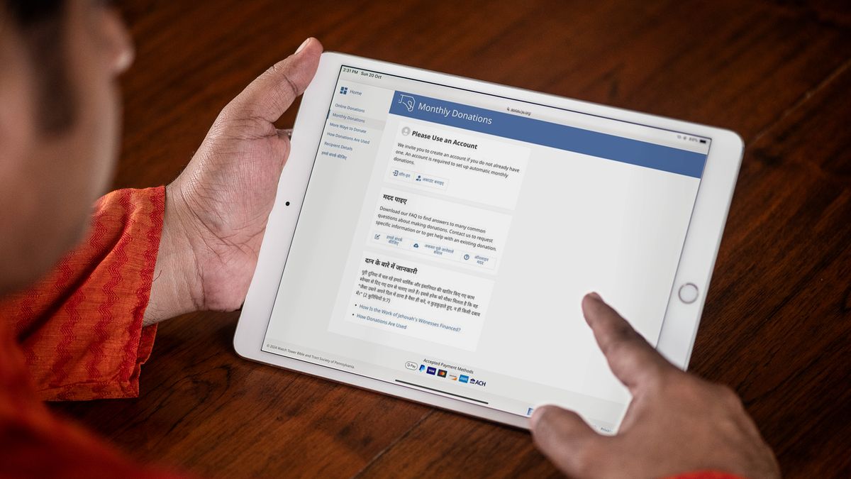 Seorang lelaki menggunakan tablet untuk membuat tetapan bagi sumbangan bulanan secara berulang.