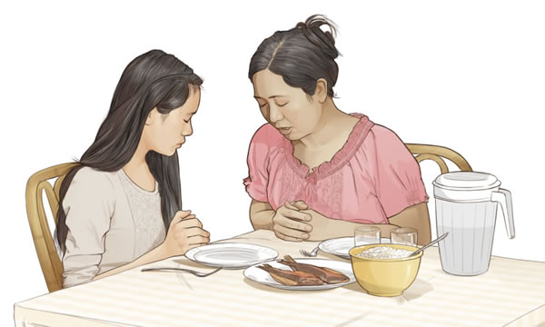 Seorang ibu berdoa bersama anak perempuannya sebelum makan