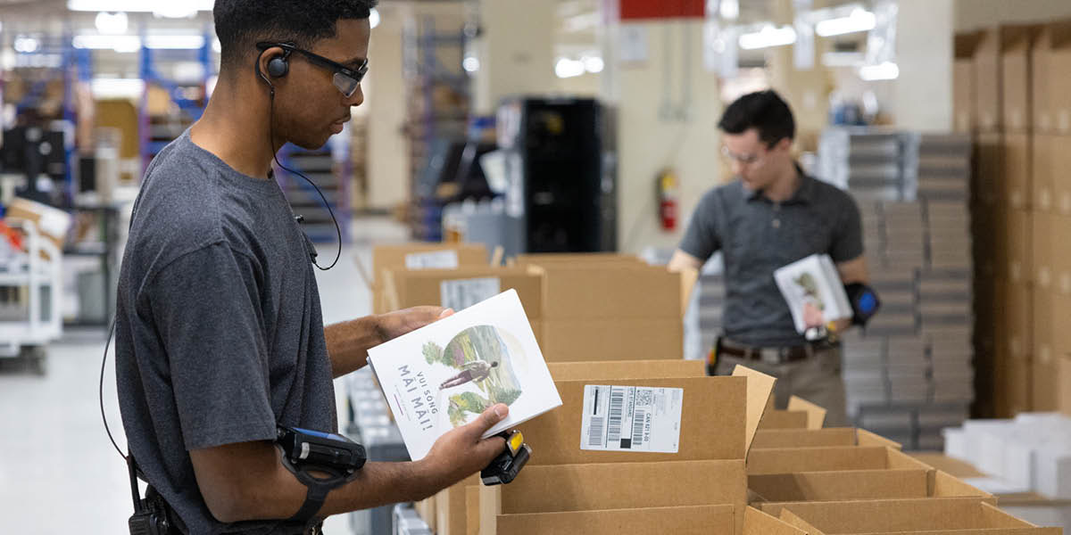 两个弟兄把书本装箱。