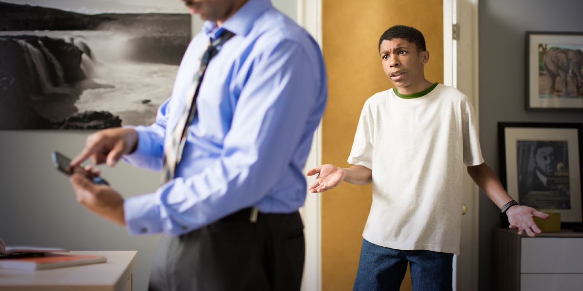 一个爸爸看儿子的手机，儿子不高兴